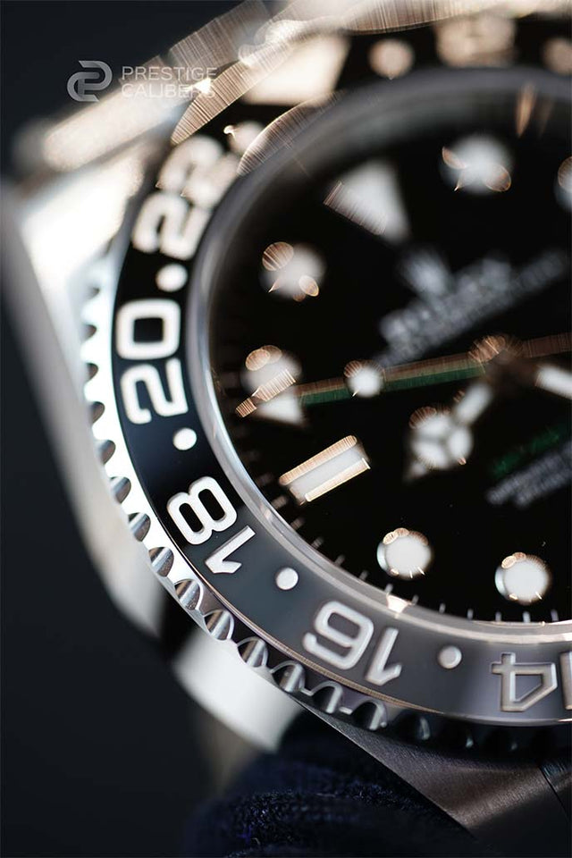 Close-up of a Rolex watch with a black dial and two tone bezel. Rolex 126710GRNR