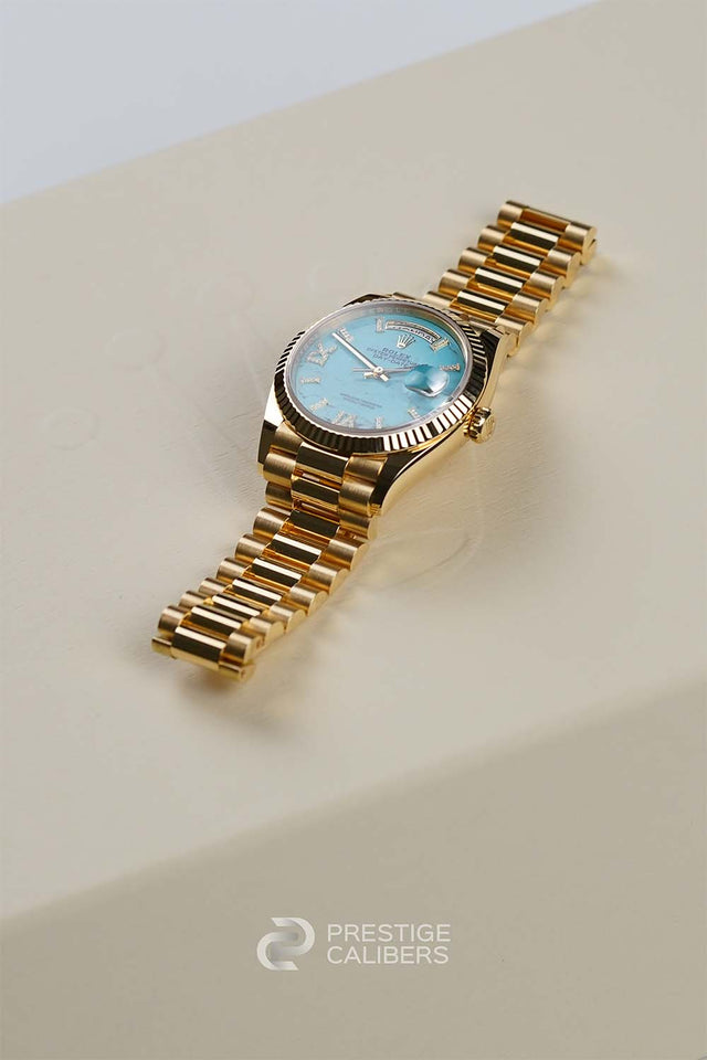 Yellow Gold Rolex Oyster Perpetual Day-Date 36 Turquoise Woman's watch 128238-0071 with a blue face on a box