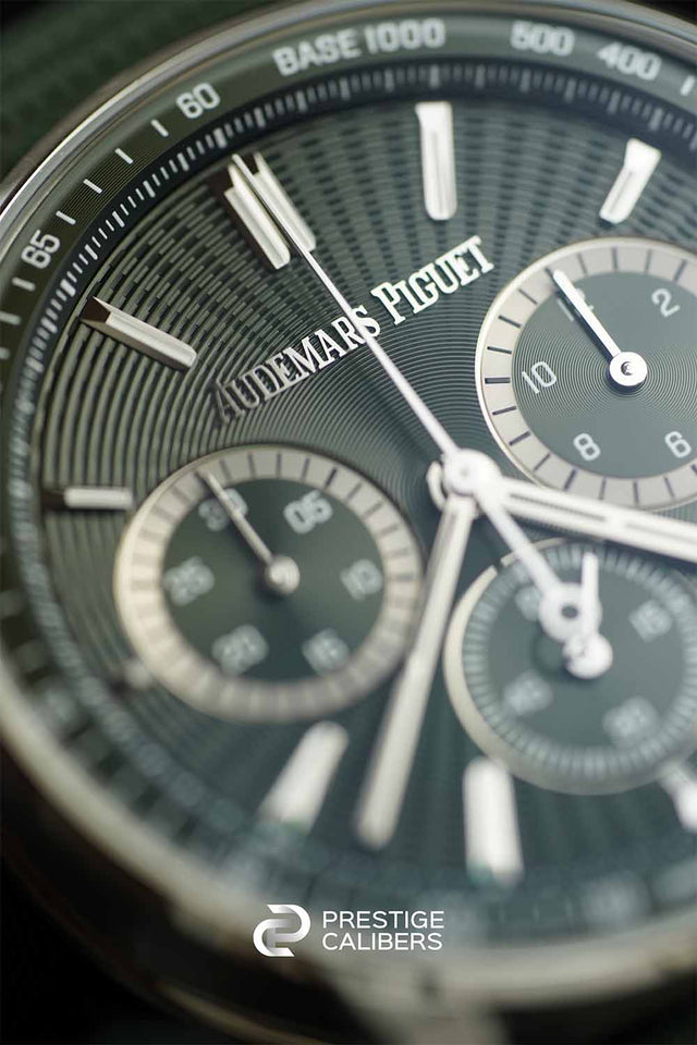 Close-up of audemars piguet watch face with visible brand name and 'Prestige Calibers' logo.