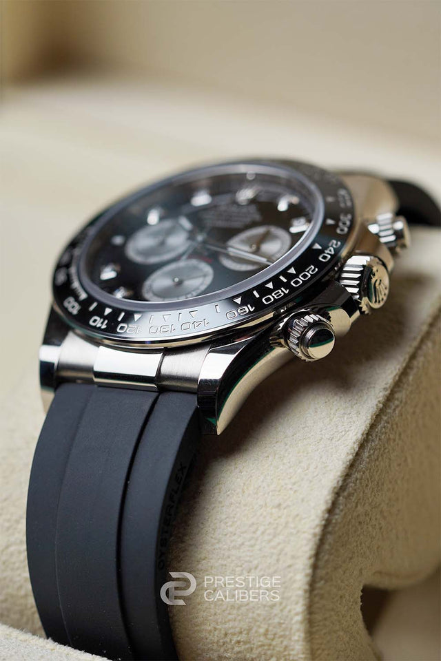 Luxury watch Rolex Daytona 126519LN-0004 with black strap and white gold case on a beige cushion inside Rolex box