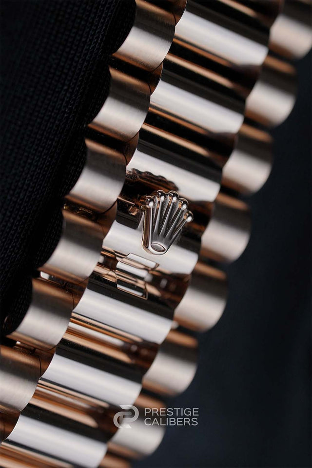 Close-up of a Rolex Day-Date 40mm 228235-0055 bracelet with the brand logo, on a dark background.