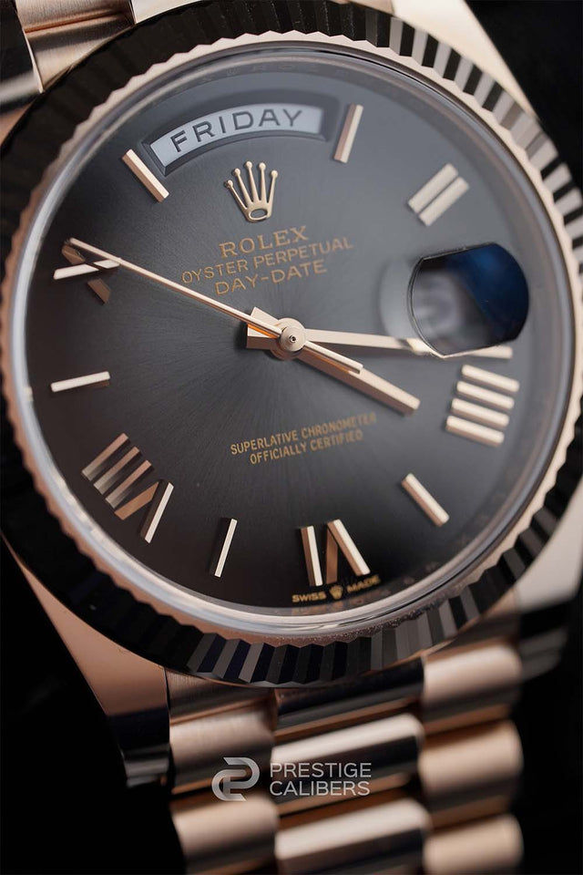 Close-up of a Rolex 228235-0055 watch with a black face and gold accents.