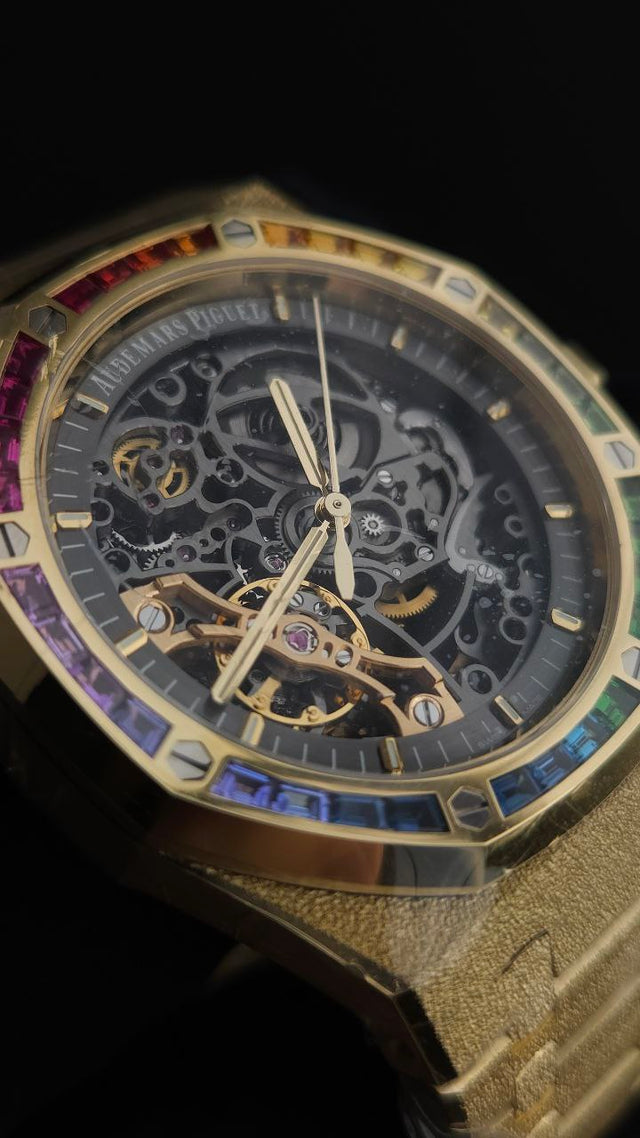 Audemars Piguet Royal Oak Frosted Gold Double Balance Wheel Openworked 15412BA.YG.1224BA.01 41 mm yellow gold men’s watch with rainbow gemstone bezel and openworked slate grey dial